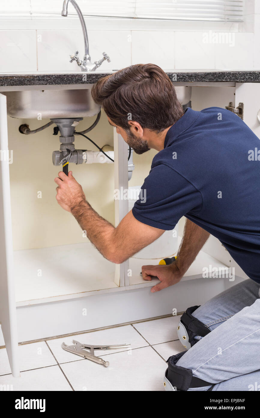 Plumber fixing under the sink Stock Photo - Alamy