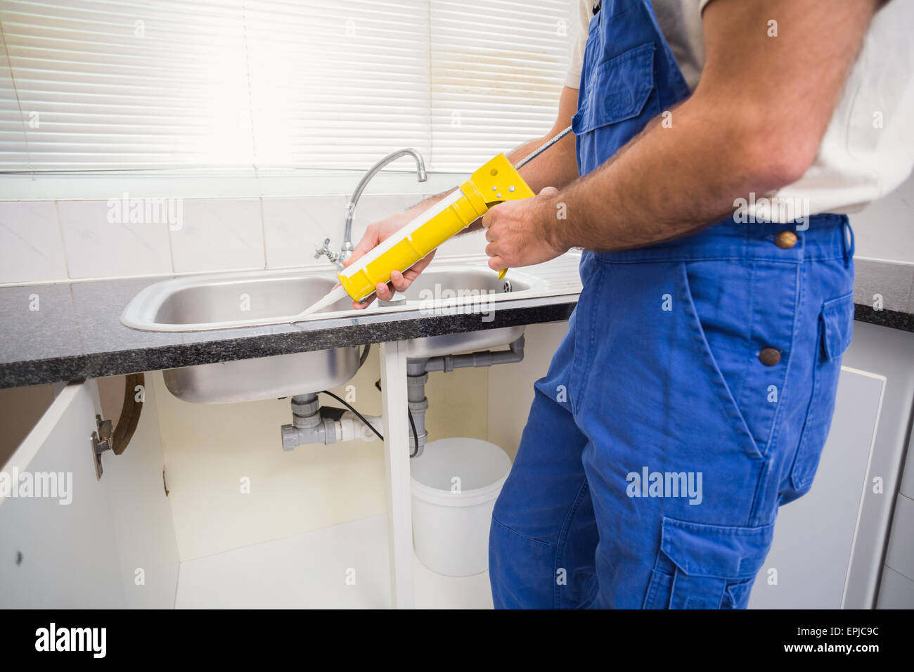 Plumber putting filling in between tiles Stock Photo Alamy