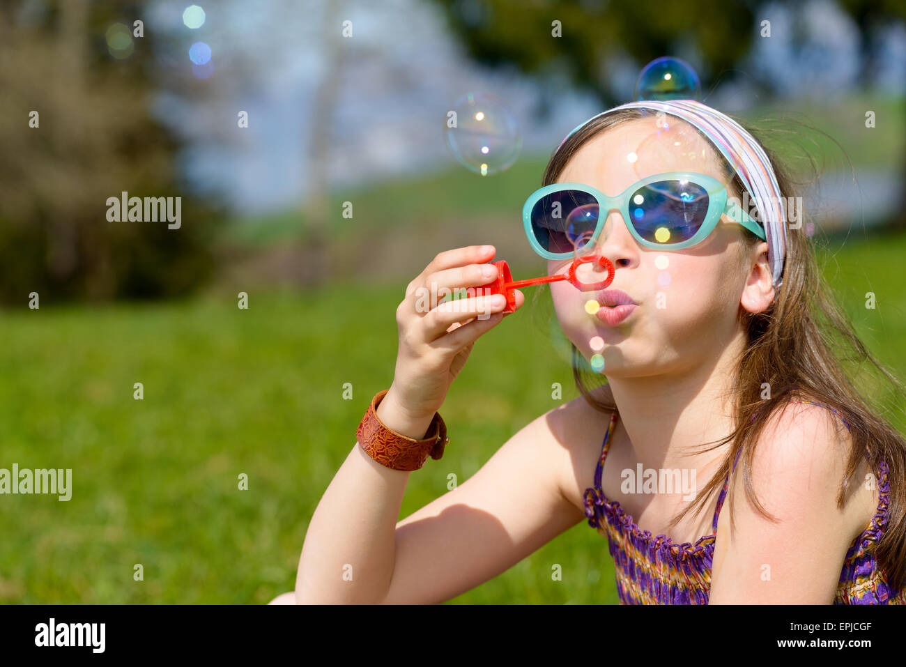 a little girl with sunglasses making soap bubbles Stock Photo - Alamy