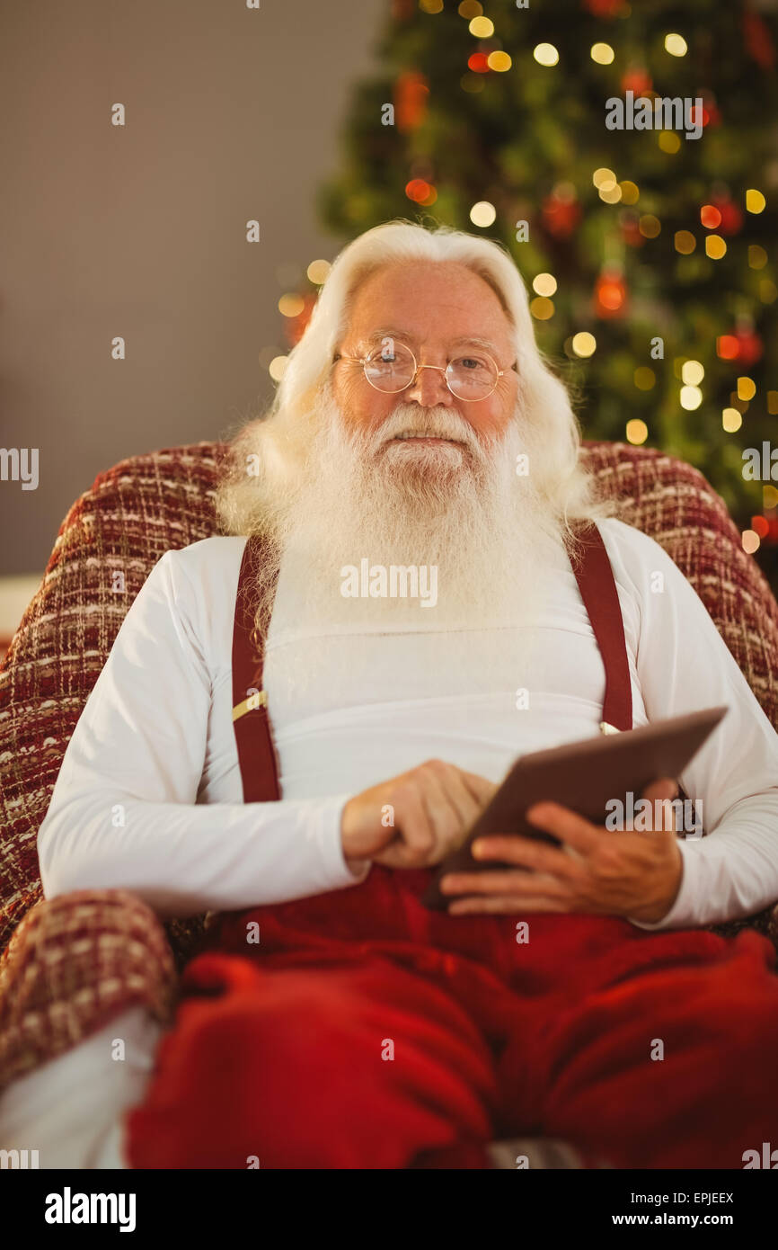 Happy santa using digital tablet Stock Photo - Alamy