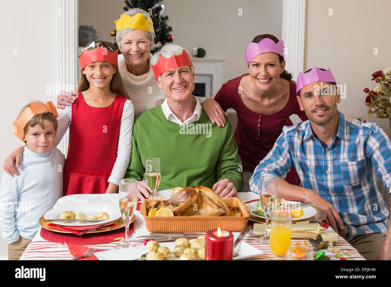 Happy extended family in party hat at dinner table Stock Photo Alamy