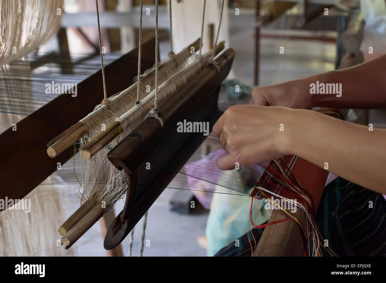 Woman weaving silk in traditional way at manual loom. Laos Stock Photo