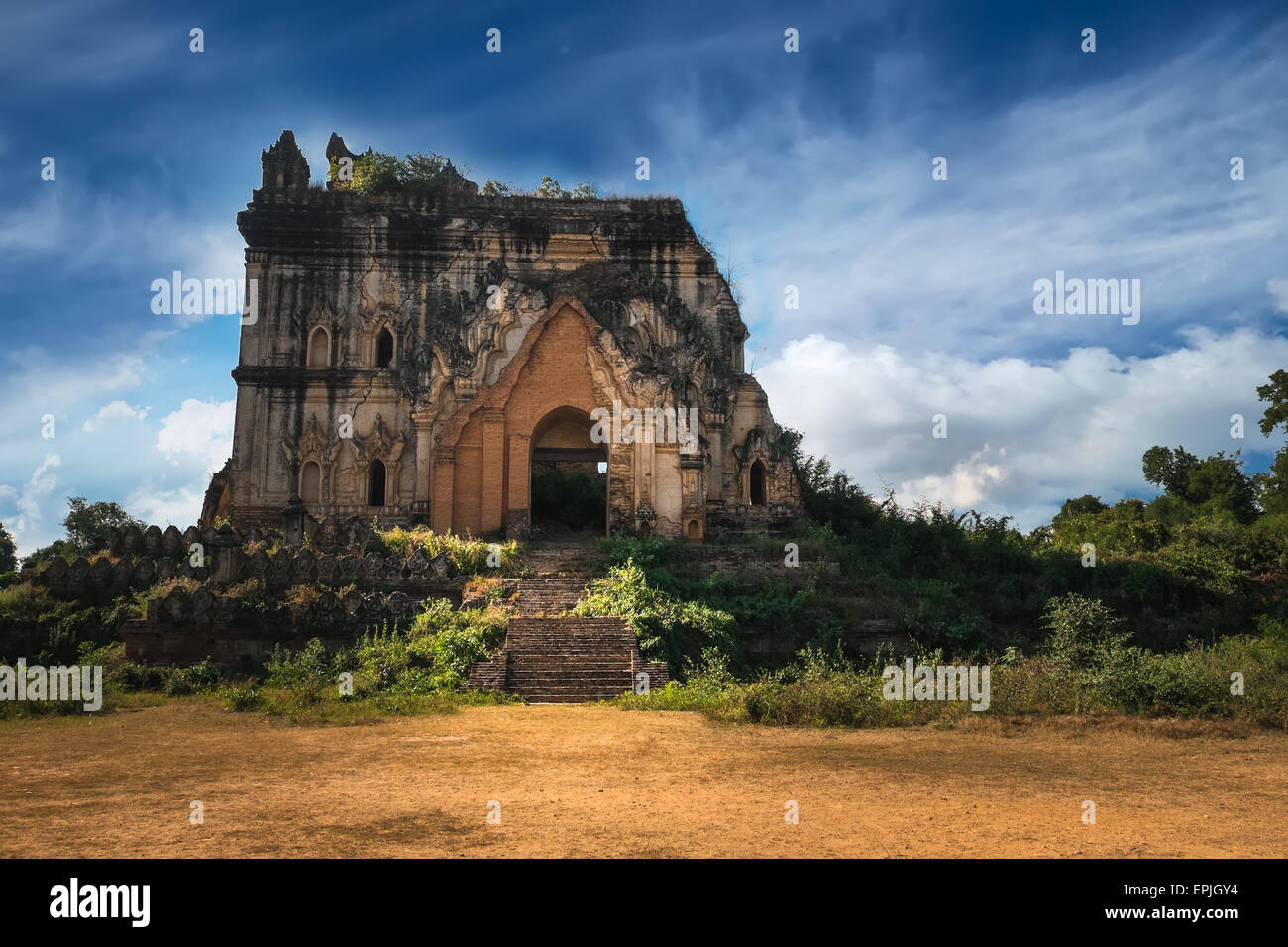 Cloudy sky over amazing architecture of old Buddhist Temple ruins at Inwa city near Mandalay. Myanmar (Burma) travel landscapes Stock Photo