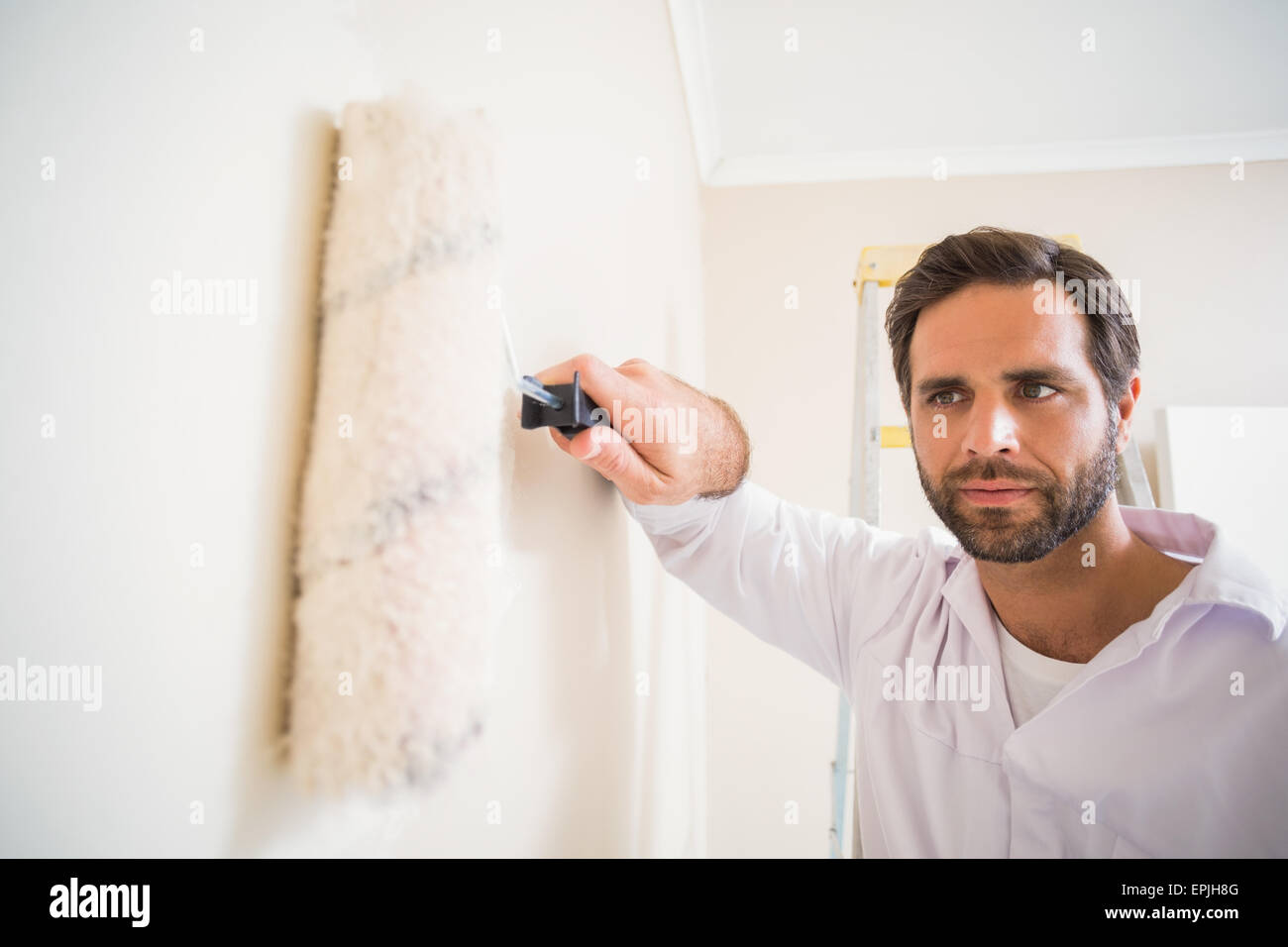 Painter painting the walls white Stock Photo Alamy