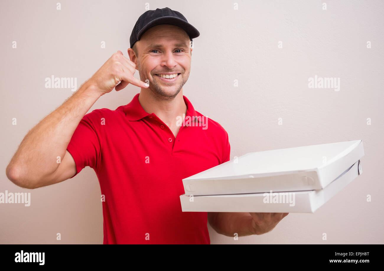 Pizza delivery man making phone call gesture Stock Photo - Alamy
