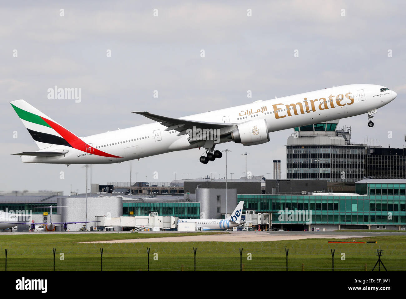 Emirates Boeing 777-300 climbs away from runway 05L at Manchester airport. Stock Photo