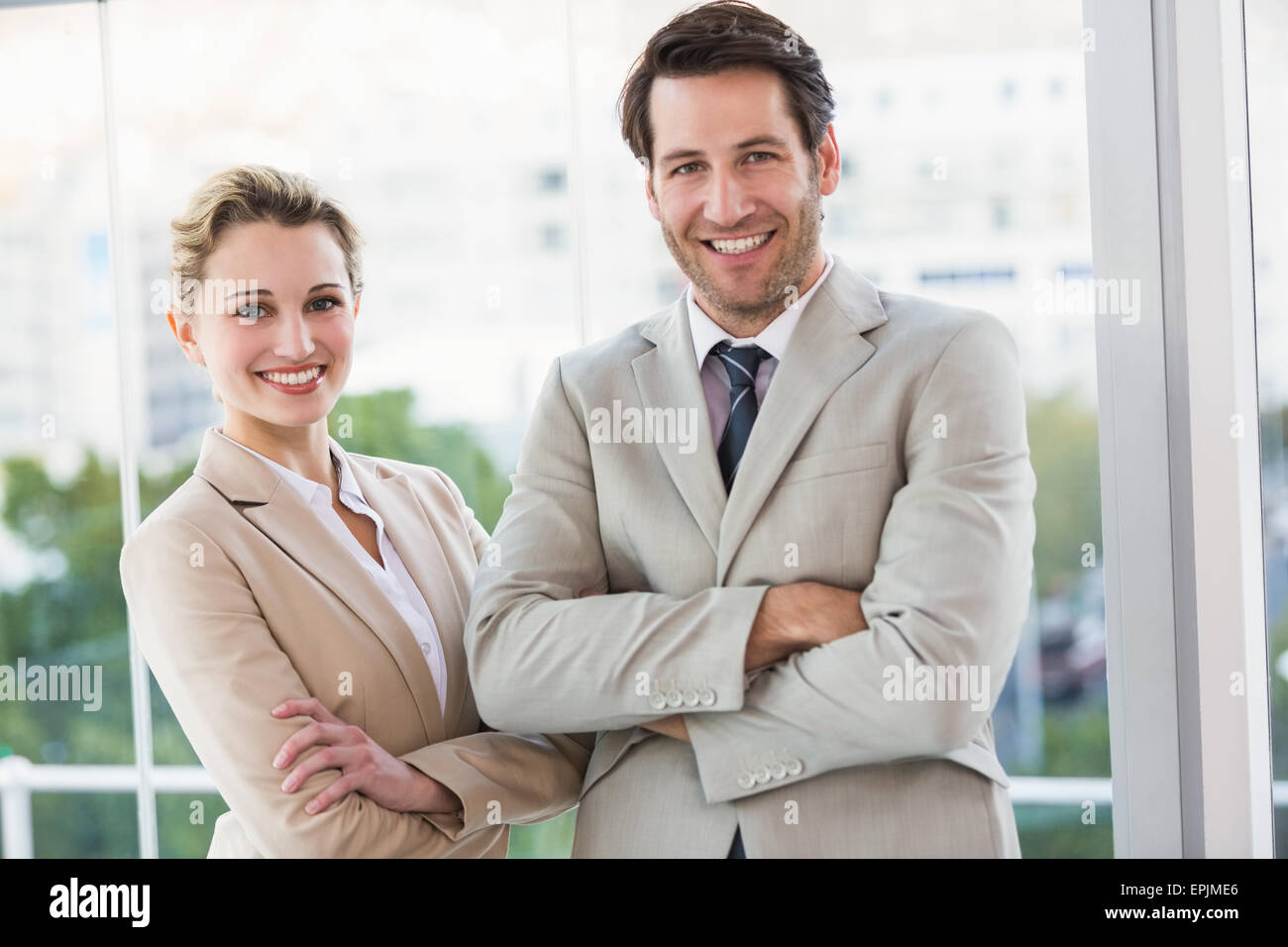 Business people posing with arms crossed smiling at camera Stock Photo ...