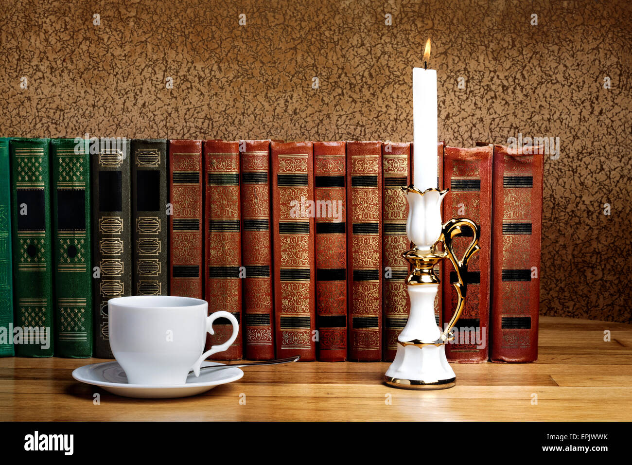 Hot cup of fresh coffee on the wooden table with  candle and book Stock Photo