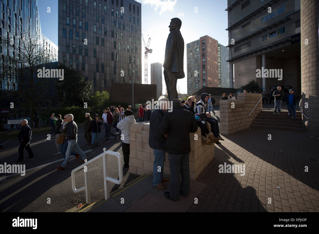 Supporters walking past the statue to former manager Sir Bobby Robson, situated outside the Milburn Stand of the stadium after Newcastle United host Tottenham Hotspurs in an English Premier League match at St. James' Park. The match was boycotted by a section of the home support critical of the role of owner Mike Ashley and sponsorship by a payday loan company. The match was won by Spurs by 3-1, watched by 47,427, the lowest league gate of the season at the stadium. Stock Photo