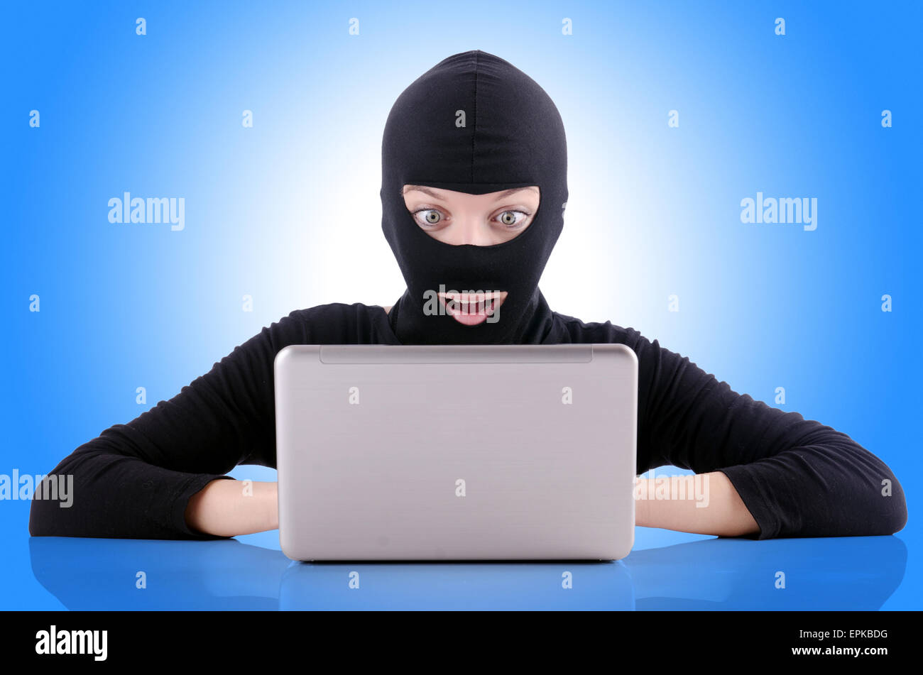 Hacker with computer wearing balaclava Stock Photo - Alamy