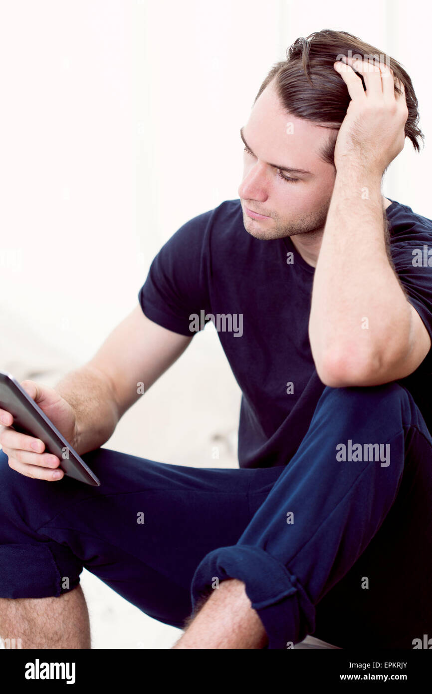 Man using mini tablet Stock Photo - Alamy