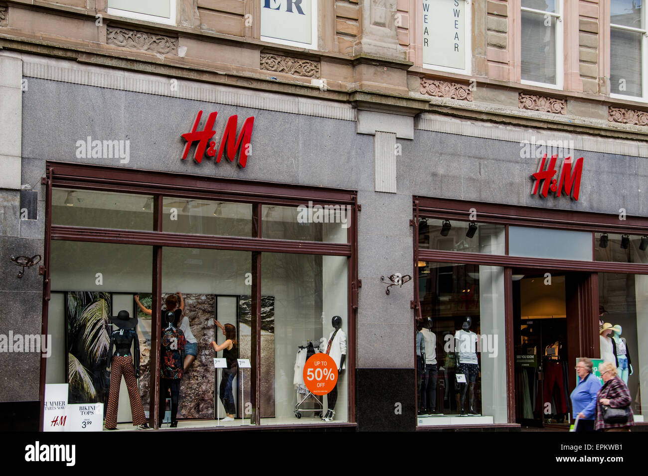 Dundee, Scotland, UK, 19th May, 2015. H&M Spring-Summer Sales: H&M Sales  staff window dressing and displaying adverts of 50% sales on Summer fashion  in Dundee High Street. Credit: Dundee Photographics/Alamy Live News