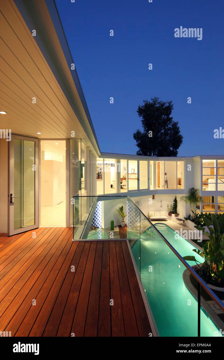 Night view along the balcony overlooking the pool and patio, Seabright Residence, Los Angeles