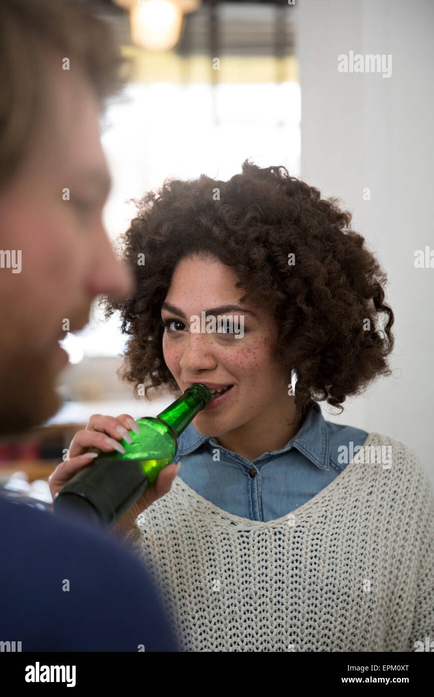 Young woman drinking beer looking at man Stock Photo Alamy