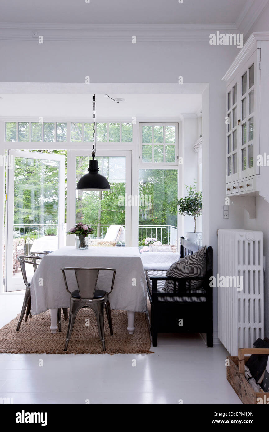 Dining room with chrome chairs and door open to garden in Hanne