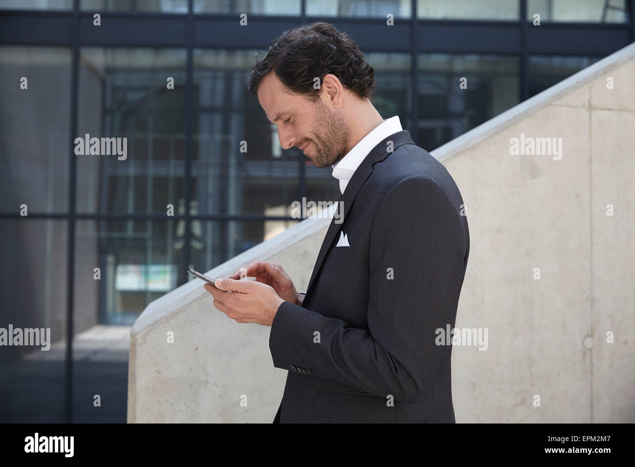 Businessman using smartphone in a modern building Stock Photo