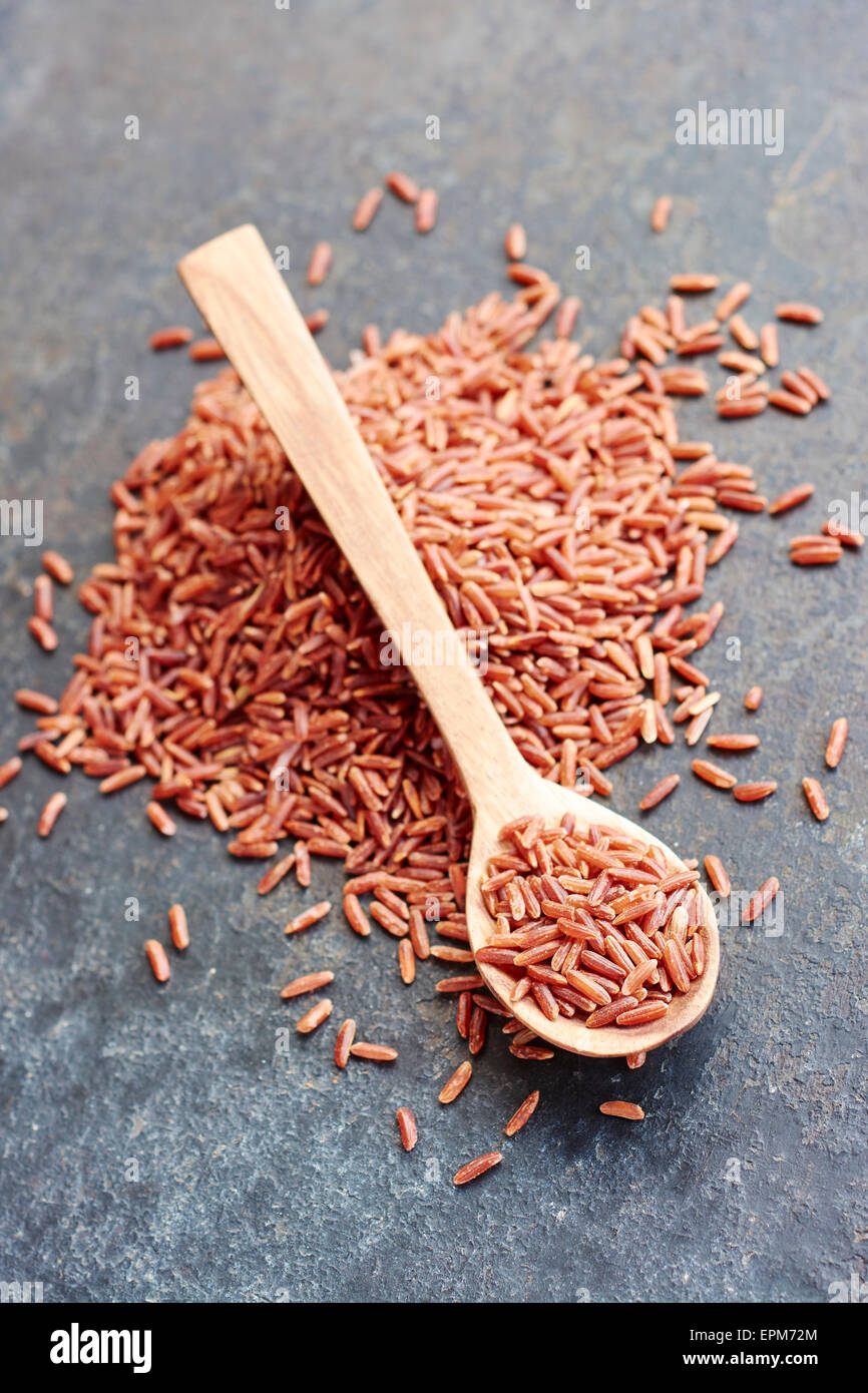Red cargo rice with a small wooden spoon on a black metal surface Stock ...