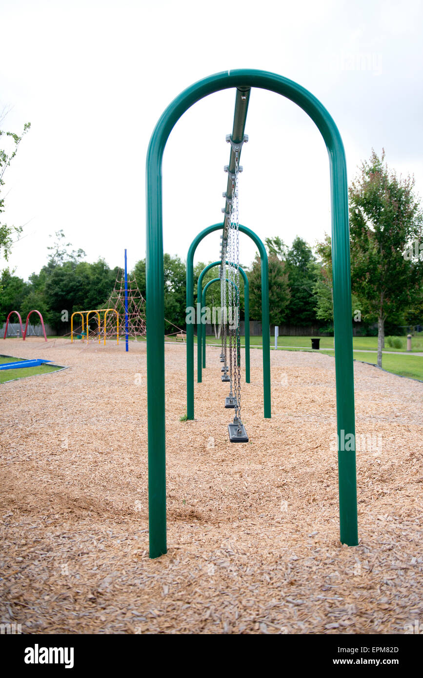 An empty row of swings at a public playground park Stock Photo