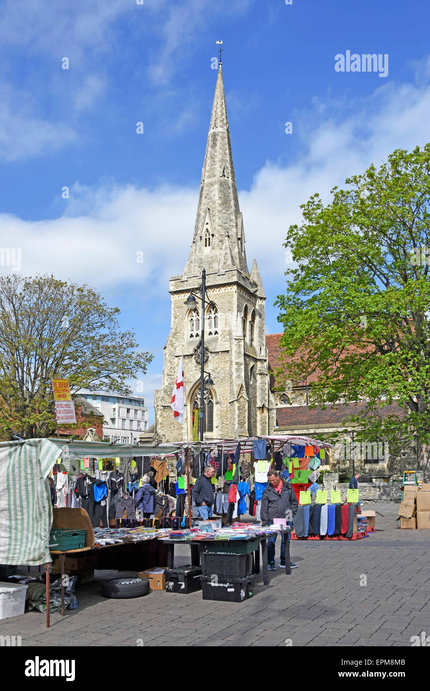 Traders stalls in Romford market with spire of Saint Edwards church