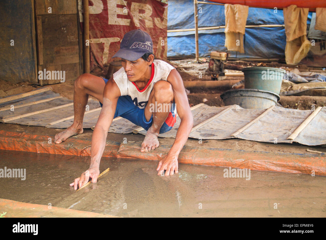 Tangerang, Indonesia. 18th July, 2014. A farmer silkworm, who works as a Silkworm seekers (Tubifex), is looking for silk worms at Cisadane River, Tanah Gocap, Tangerang. Farmer day can get 25-30 cans per tin silk worms for 5 thousand and sold in fish stores in Tangerang. © Garry Andrew Lotulung/Pacific Press/Alamy Live News Stock Photo