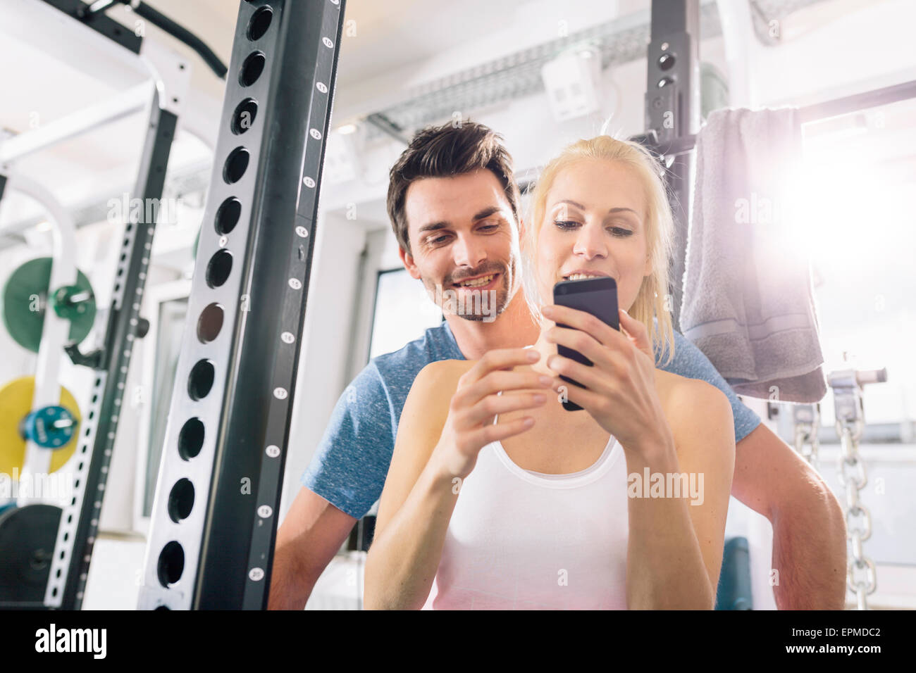 Young couple with smartphone after training at gym Stock Photo - Alamy