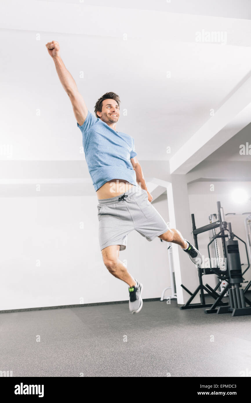 Young man jumping in the air at gym Stock Photo - Alamy