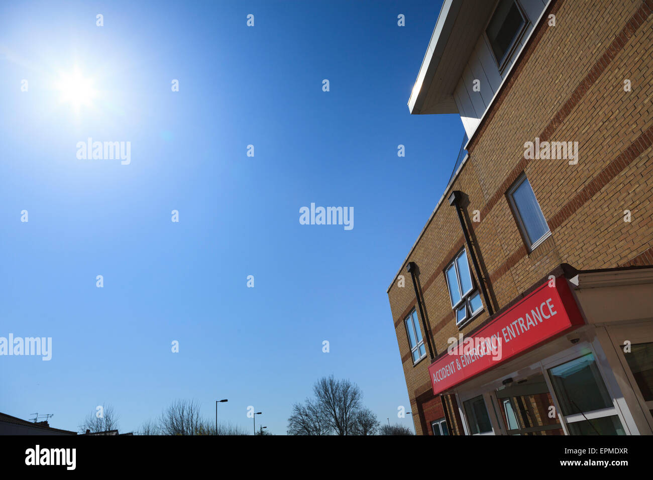 Accident and emergency entrance and sign with sun flare in blue sky Stock Photo