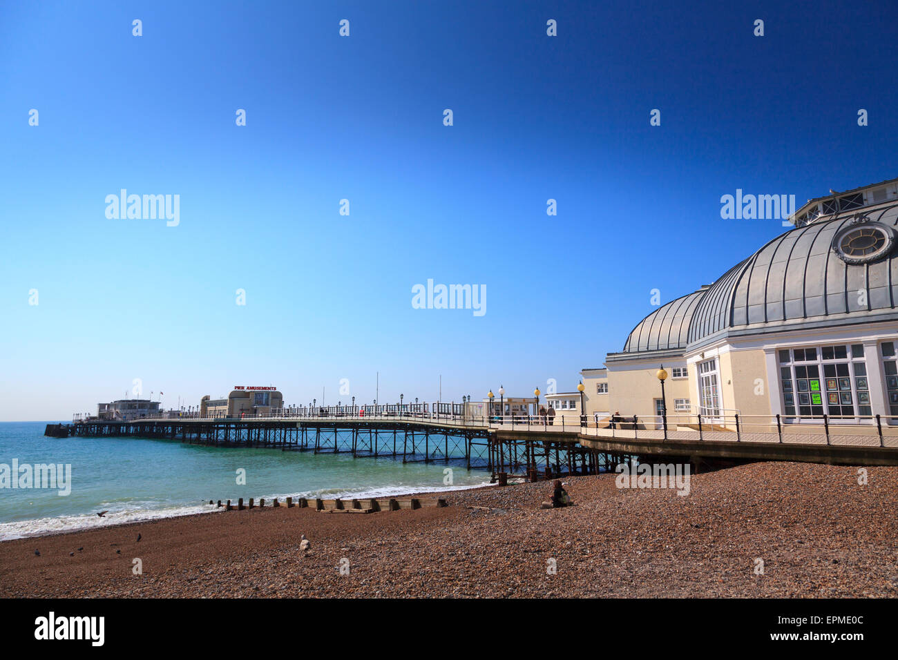 Worthing pier and shingle beach under a blue sky Stock Photo