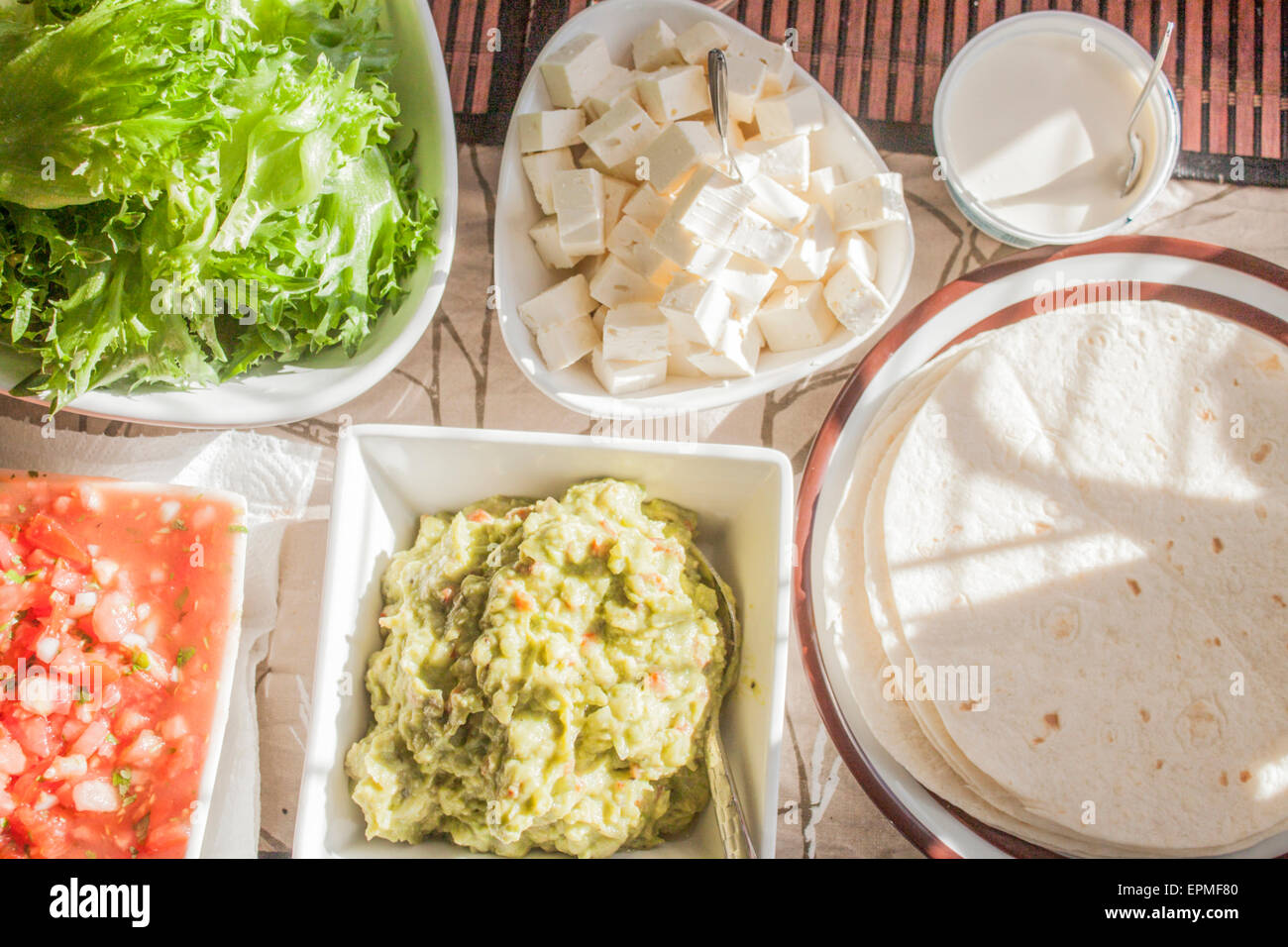 Delicious tex mex tortilla table. including tortillas,salsa, guacamole, feta cheese and salad Stock Photo