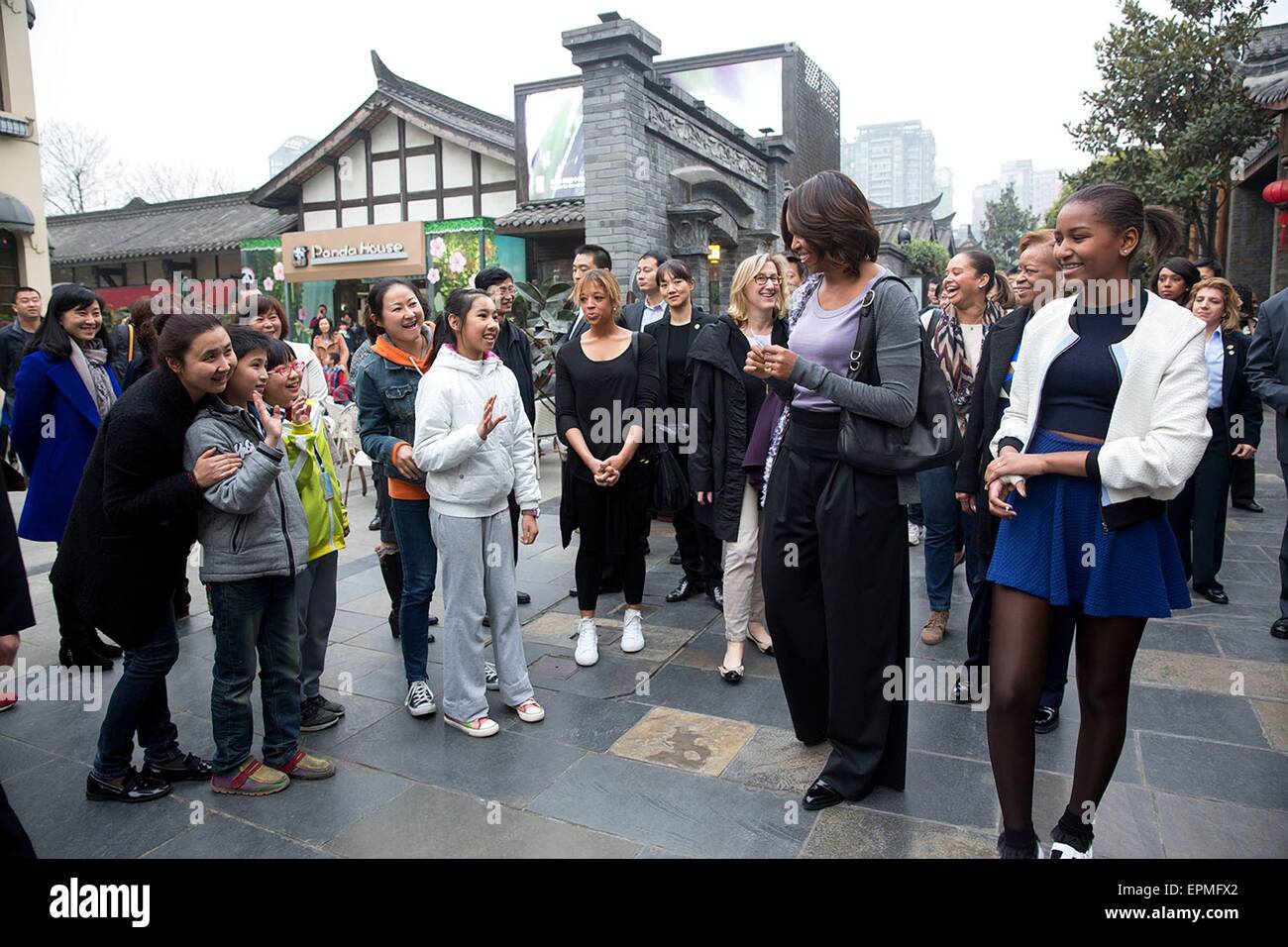 First Lady Michelle Obama with daughters Sasha and Malia greet children during a walk March 25, 2014 in Xian, China. Stock Photo