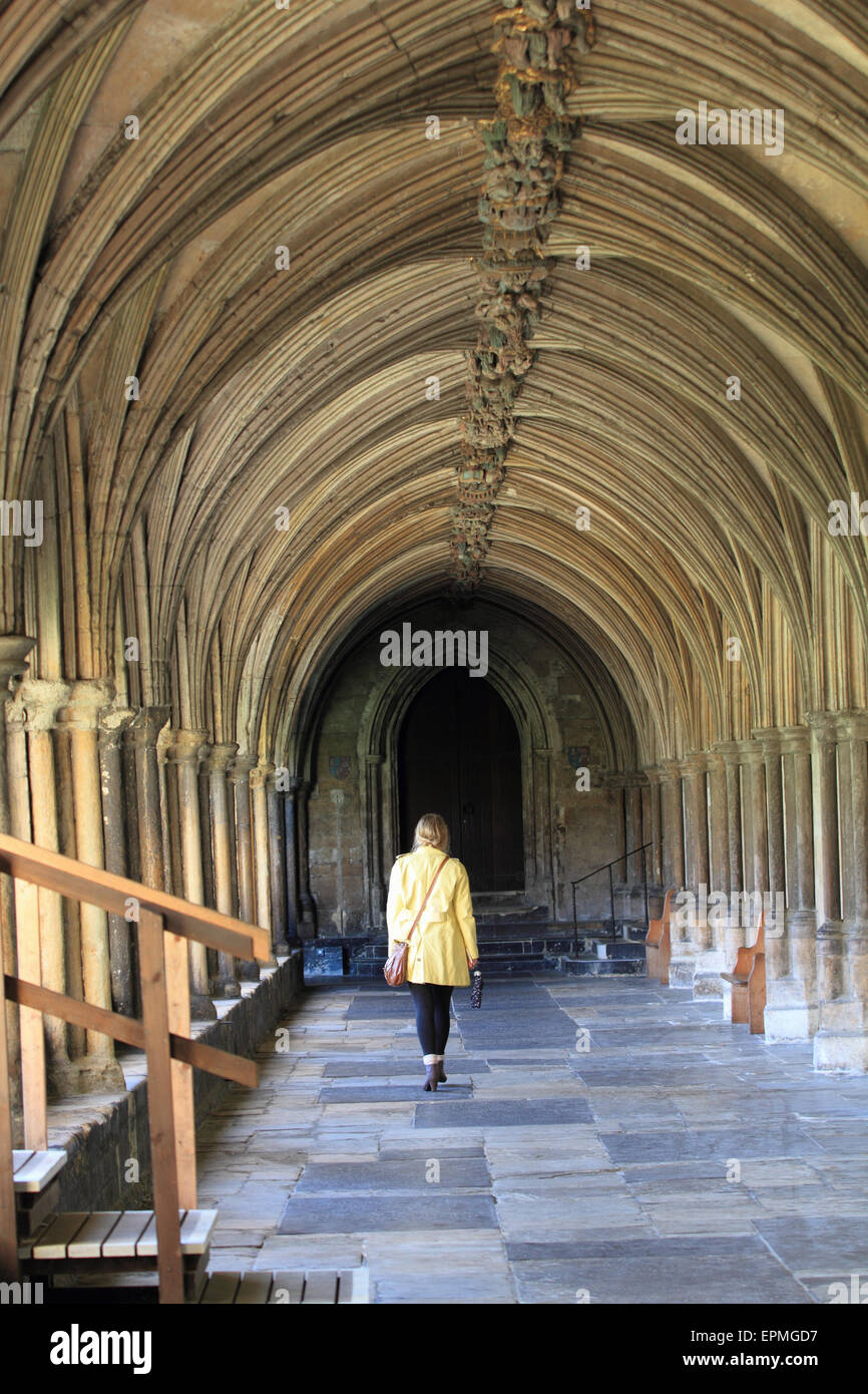 The cloisters at Norwich Cathedral, lady yellow top walking, Norwich, Norfolk, UK Stock Photo