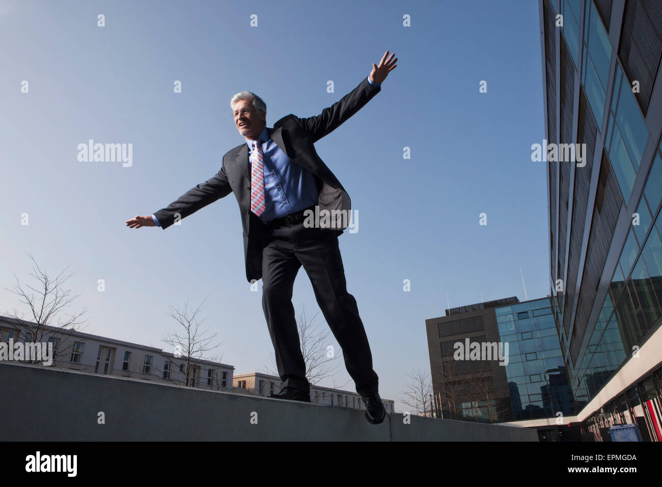 Businessman balancing on a wall Stock Photo
