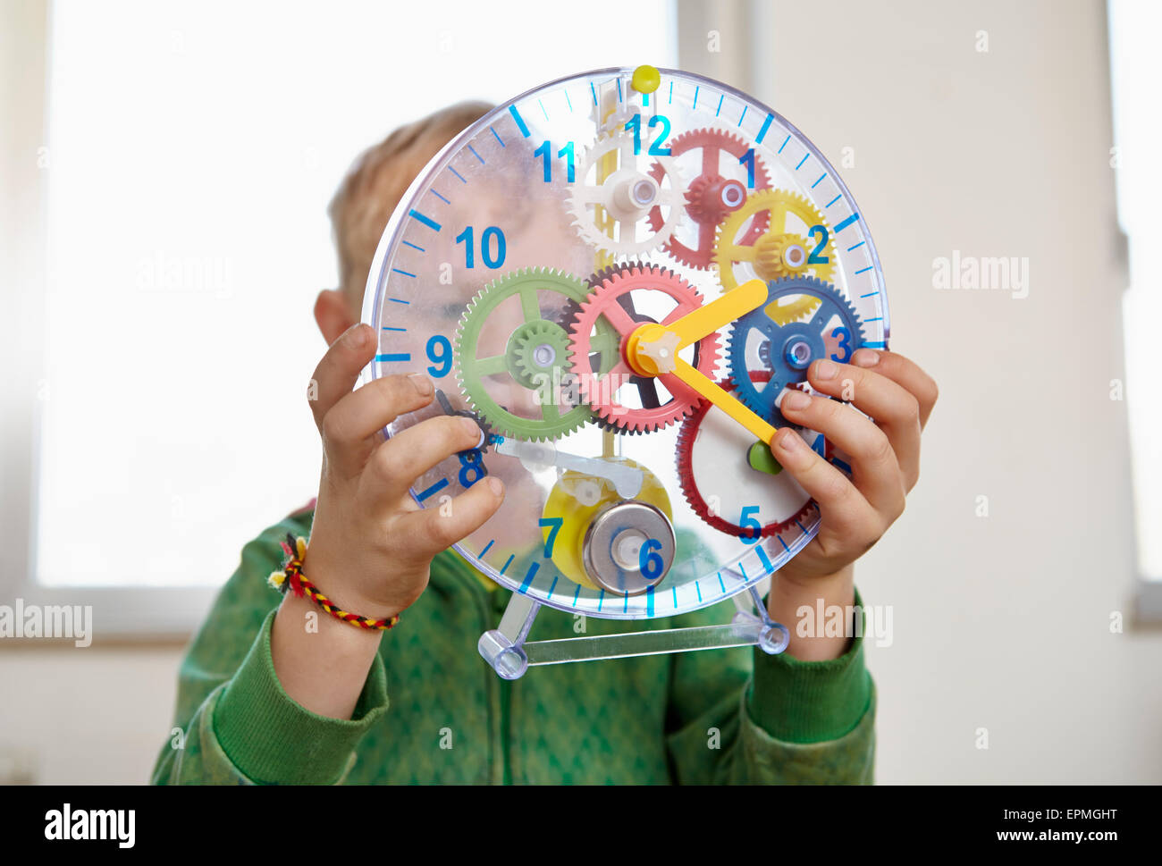 Boy playing with toy clock Stock Photo Alamy