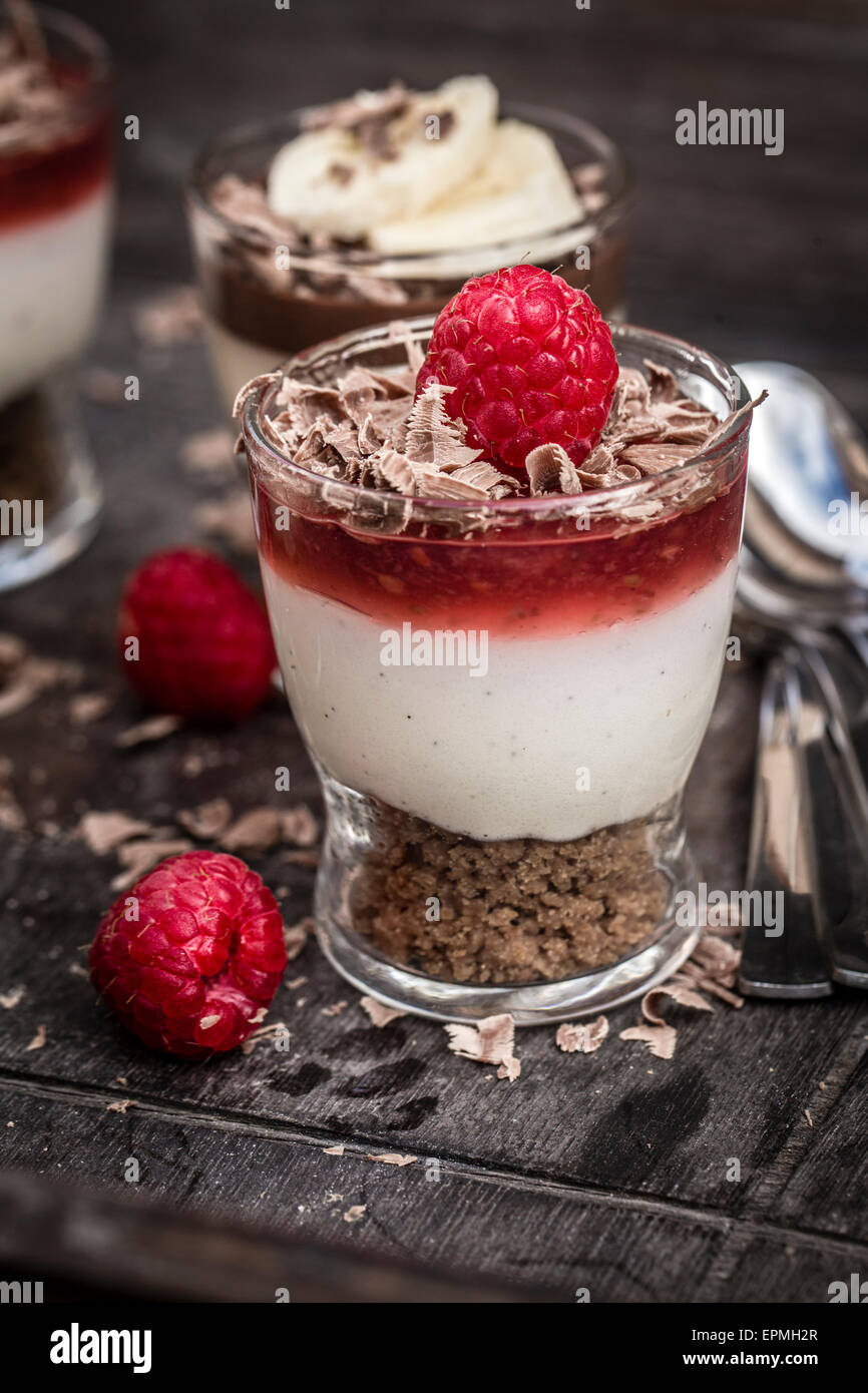 Desserts in glasses, raspberry mascarpone and speculoos and chocolate banana mascarpone and speculoos Stock Photo