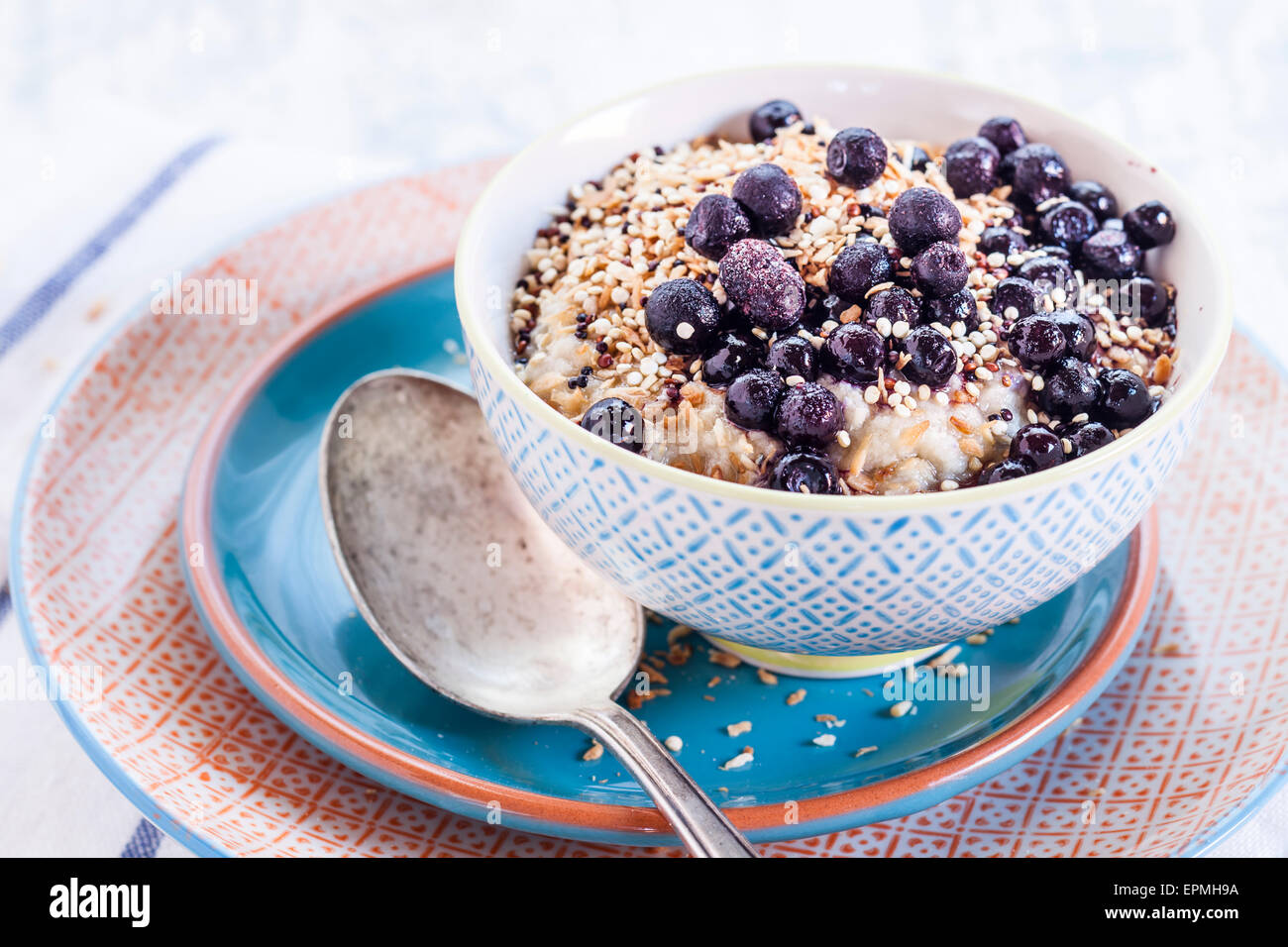 Vegan superfood breakfast with porridge, almond milk, blueberries and roasted quinoa Stock Photo