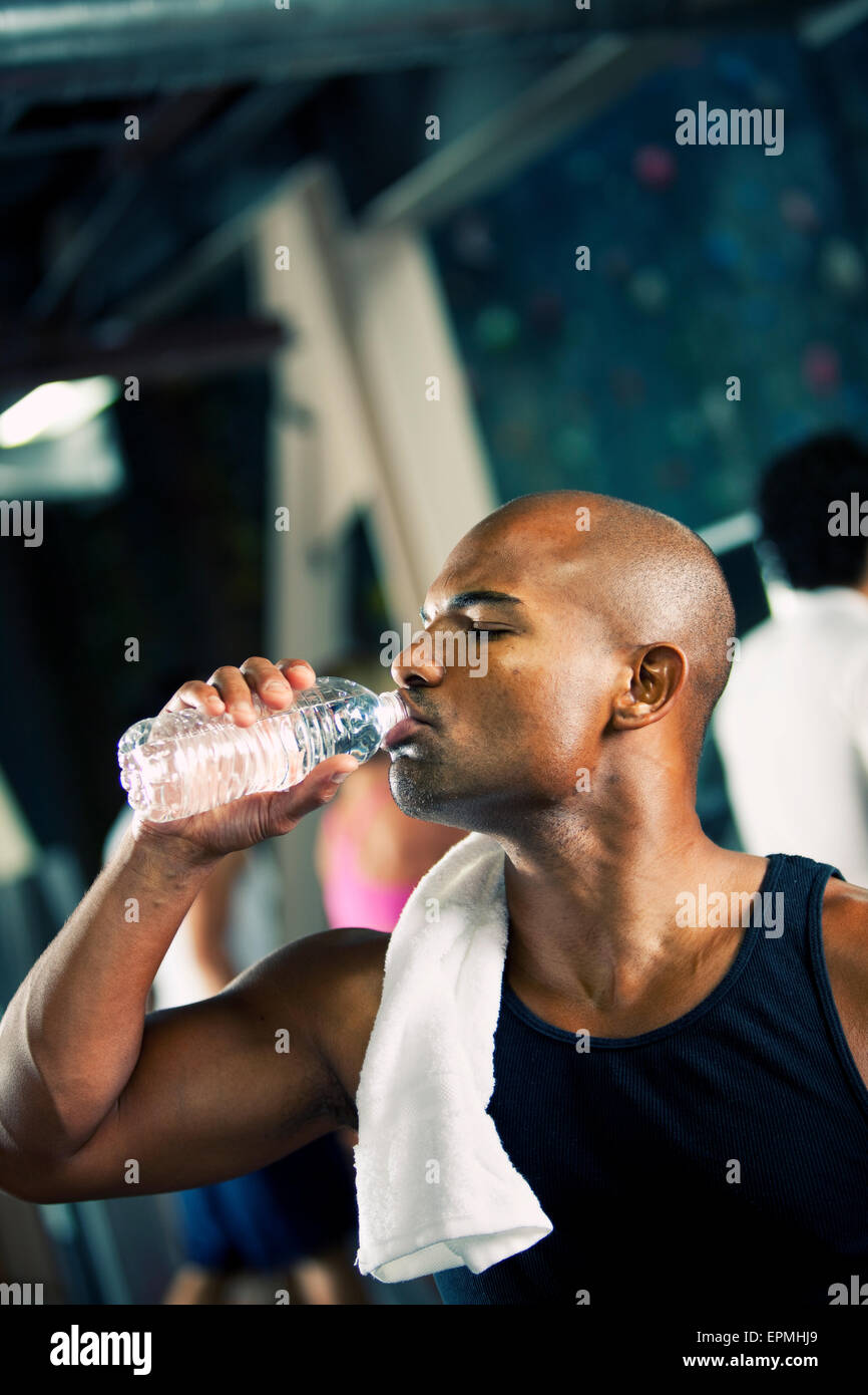 Man in a gym drinking water from bottle Stock Photo - Alamy