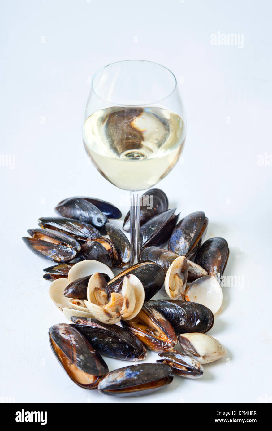 Mussels and cockles with a glass of white wine against a white background Stock Photo