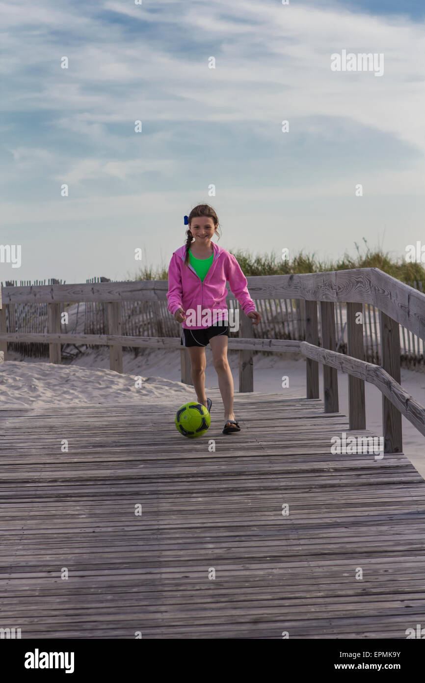 An athletic ten year old girl exercises on the beach in Long Beach, Long Island, New York. She enjoys running and soccer. Stock Photo
