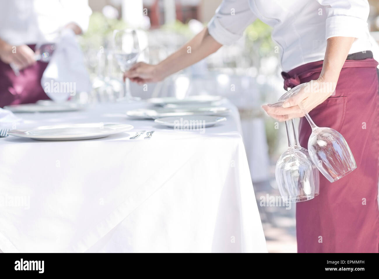 Waiter placing wine glasses on outdoor restaurant table Stock Photo Alamy