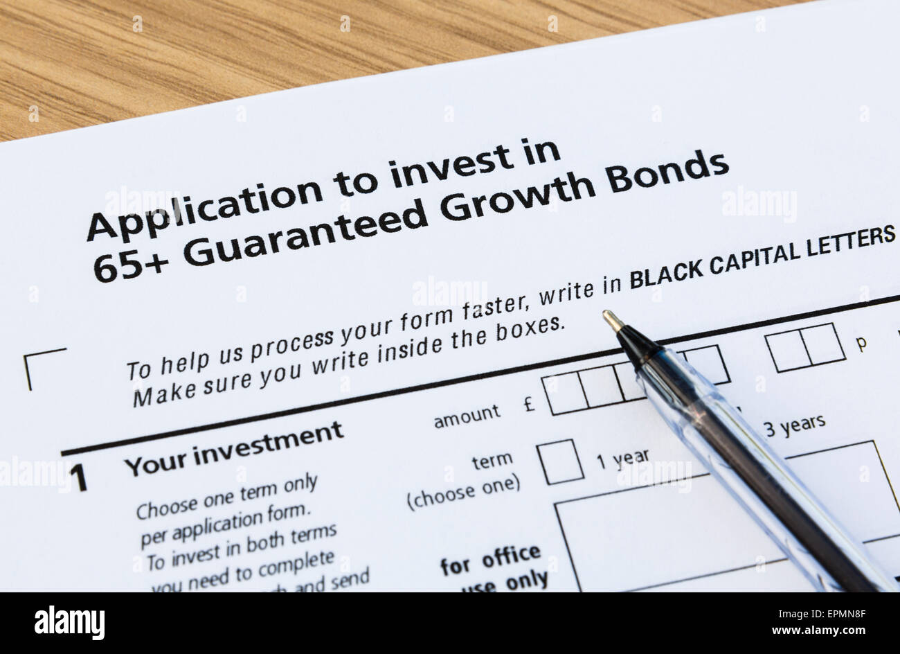 Application form to buy pensioners' 65+ Guaranteed Growth Bonds and a black ballpoint pen for completing. England UK Britain Stock Photo