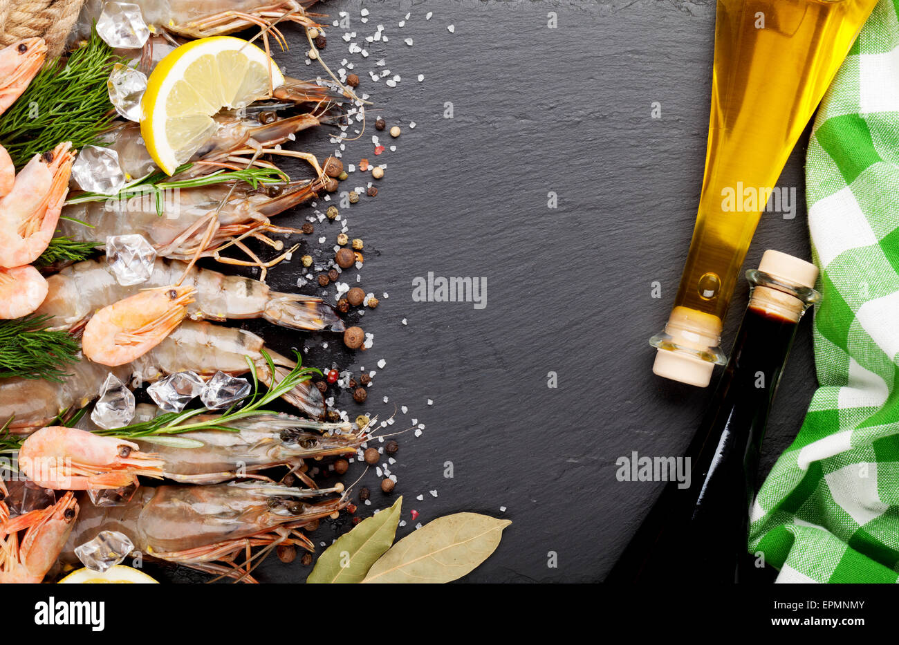 Fresh prawns with spices and condiments on black stone background. Top view with copy space Stock Photo