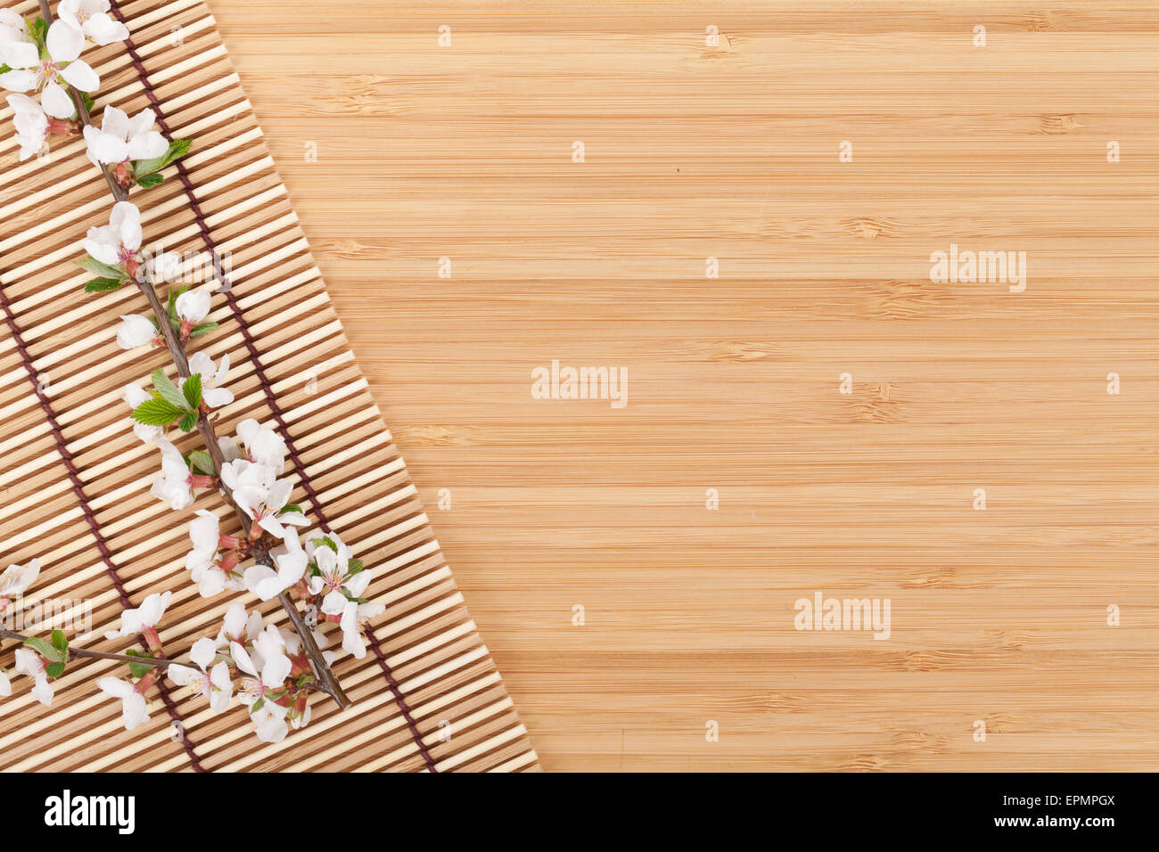 Sakura branch over bamboo mat with copy space Stock Photo