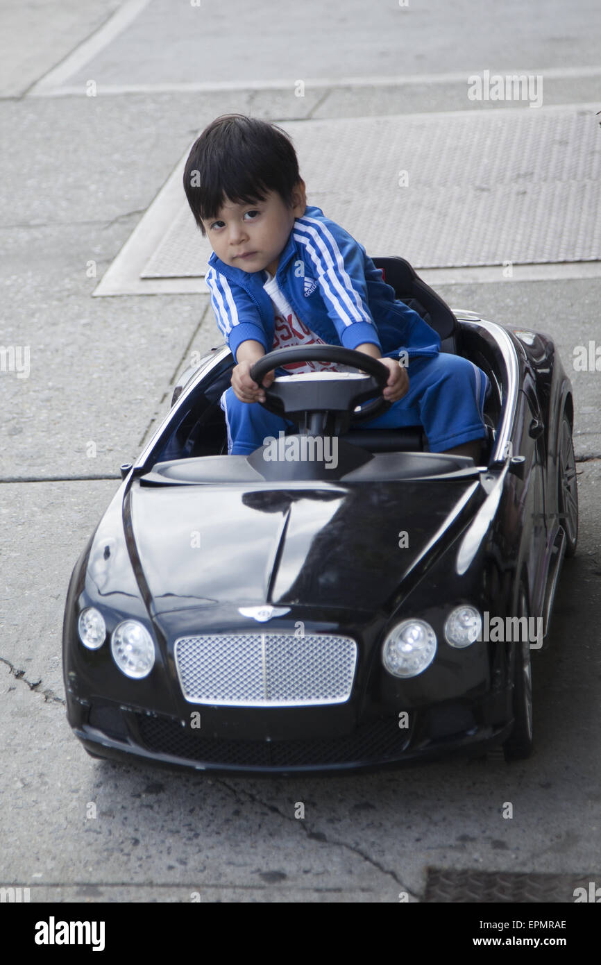 Small child riving his toy car on the sidewalk on Church Avenue, Brooklyn, NY. Stock Photo