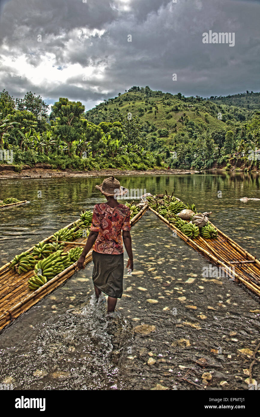 A farmer walks to a raft down river in the Grand Anse of Haiti to collect vegetables on market day. Stock Photo