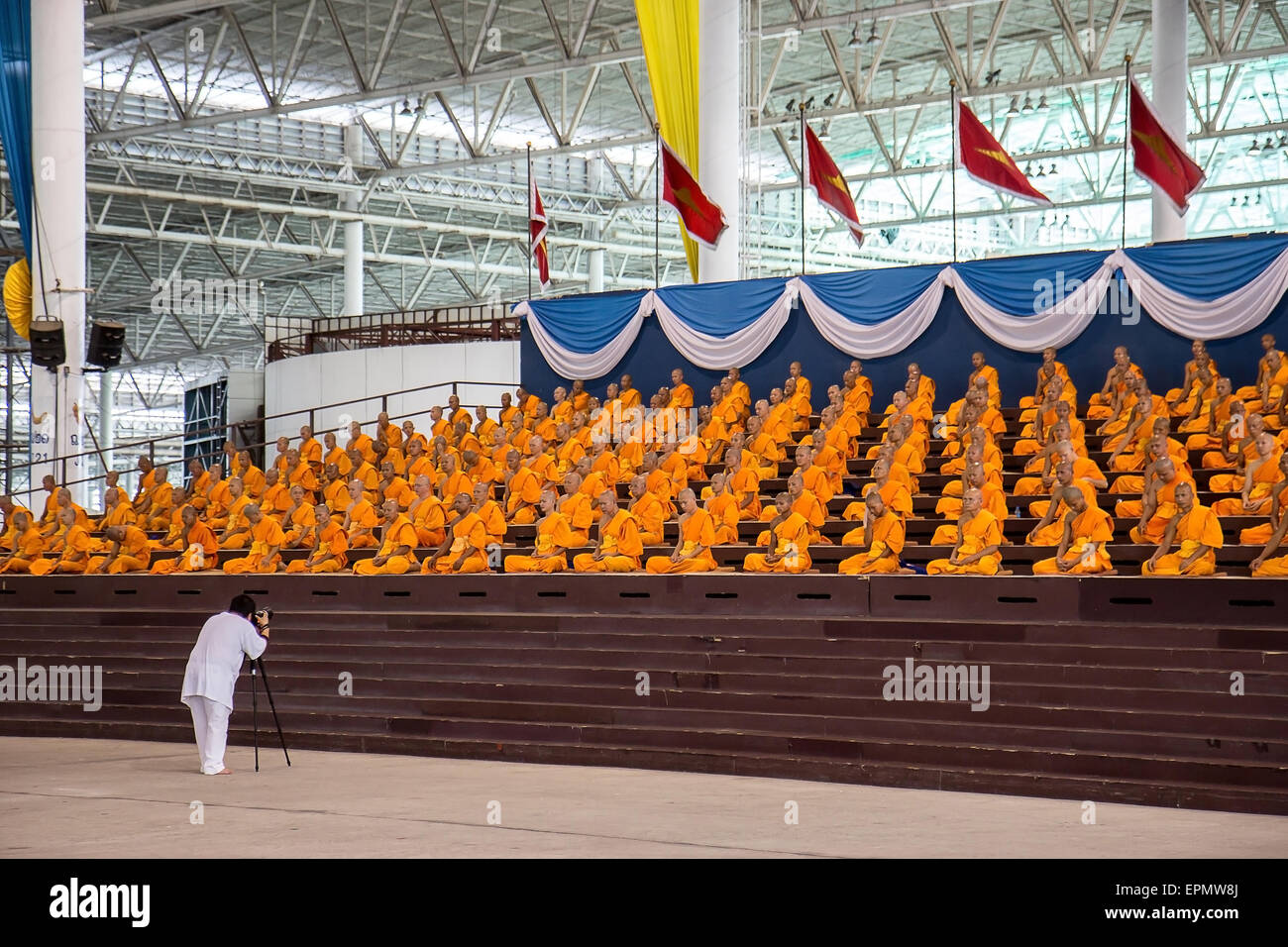 Man photographing praying monks at the Wat Phra Dhammakaya Stock Photo
