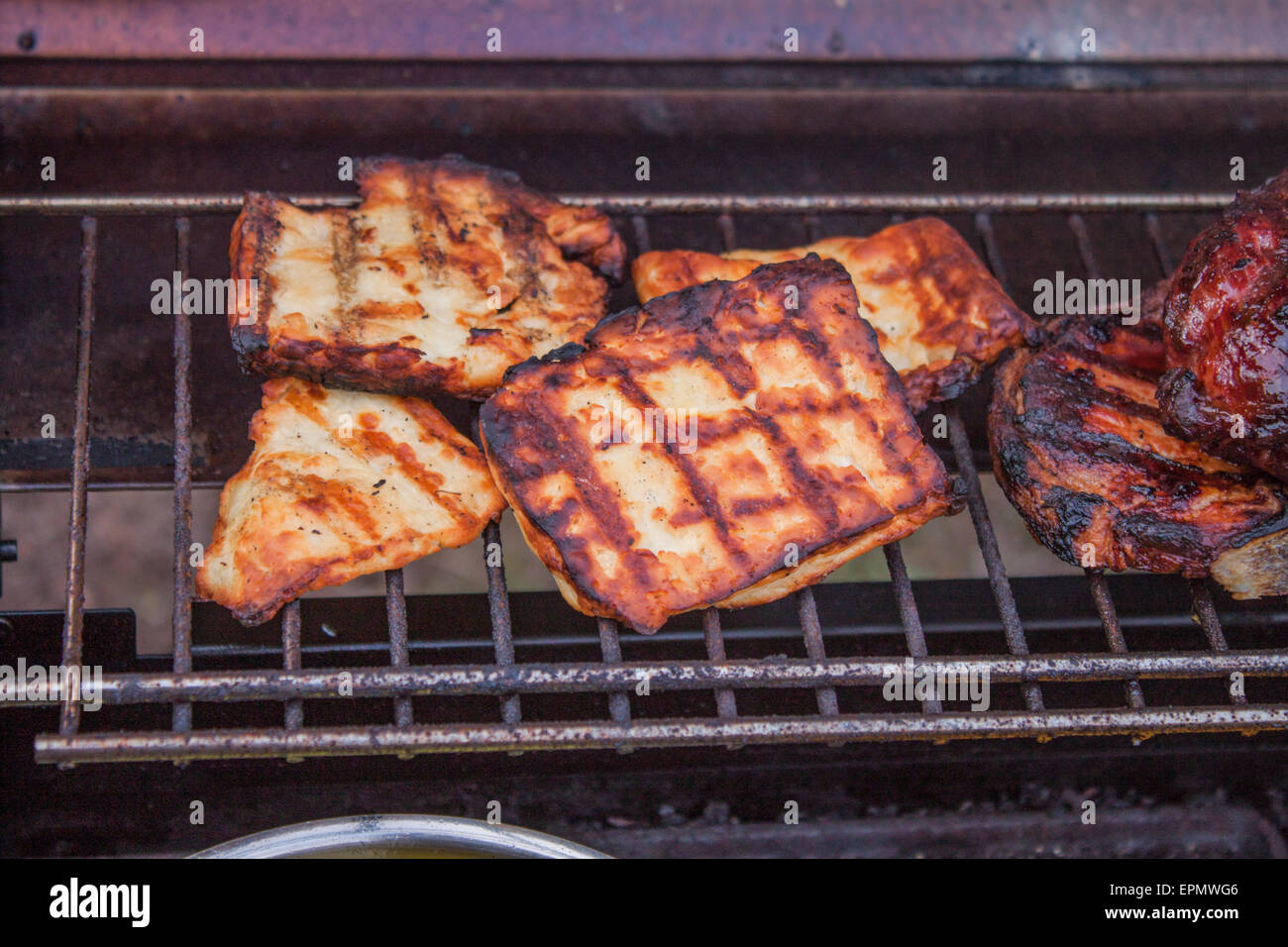 Slices of grilled halloumi, near meat, on a barbeque Stock Photo Alamy