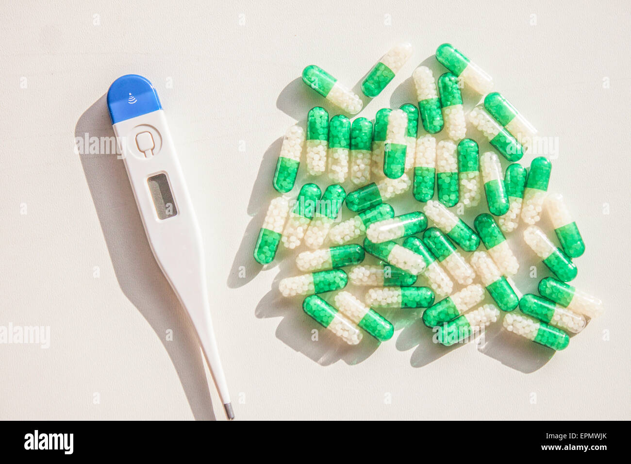 Blue - white thermometer and green - white pills Stock Photo