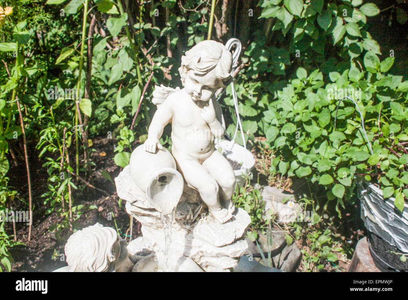 White angel statue, in a green garden Stock Photo