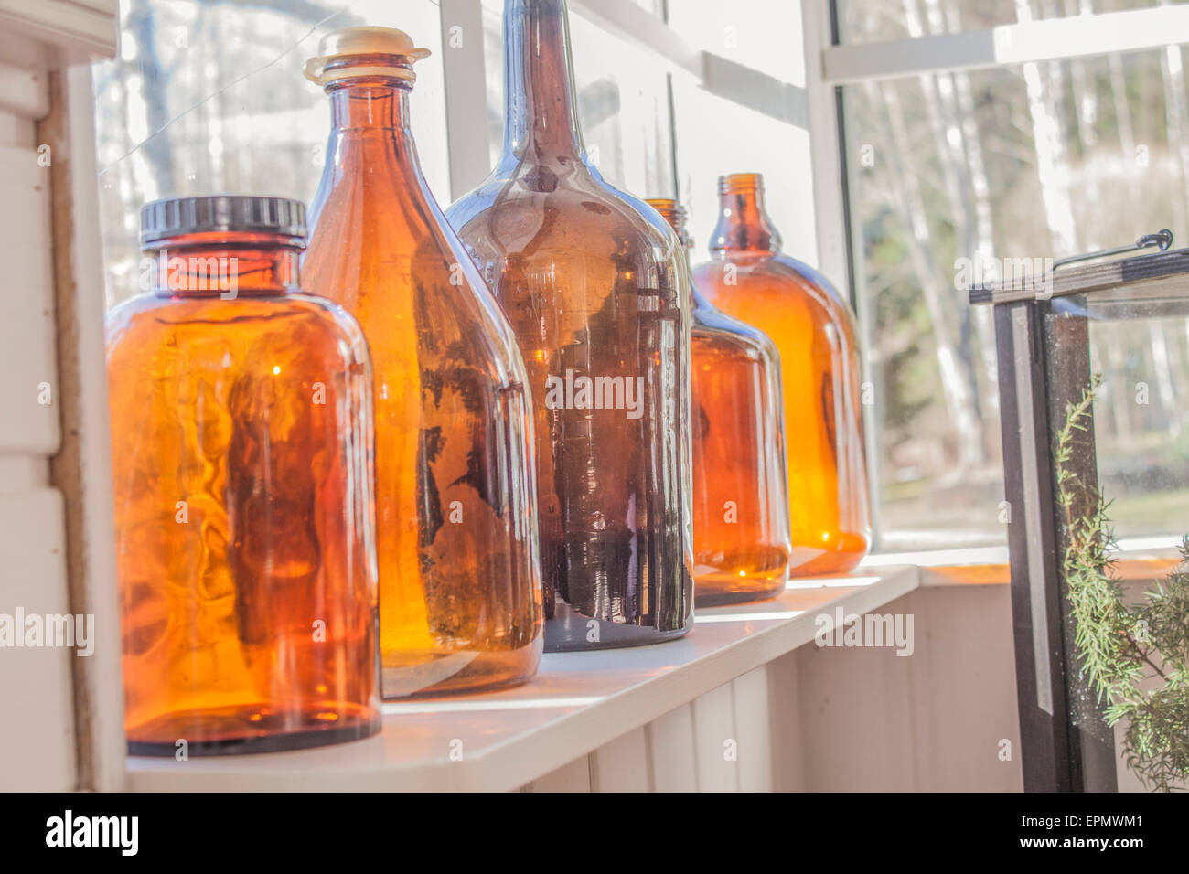 A few brown glass bottles, in front of a window Stock Photo