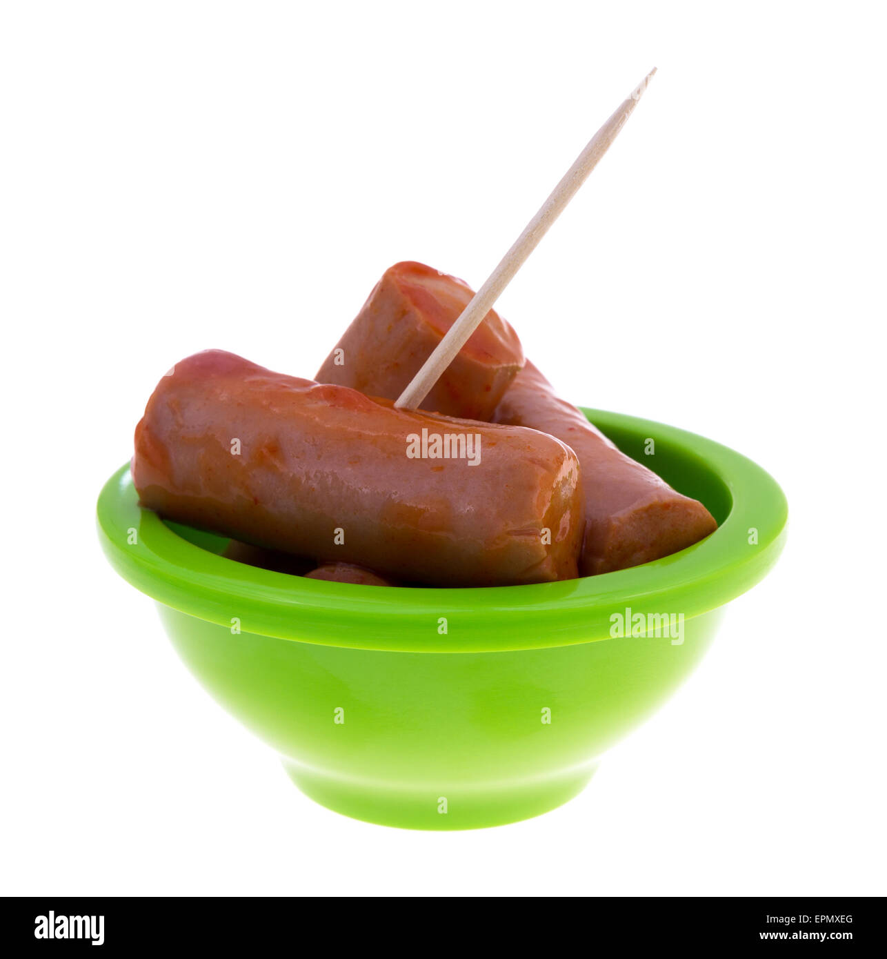 A small green bowl filled with hot and spicy bite size sausages with a toothpick inserted in a sausage. Stock Photo